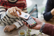 © Tom Merton/Caia Image - Woman with smart phone using contactless payment