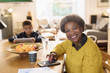 © Tom Merton/Caia Image - Portrait smiling senior woman paying bills at dining table