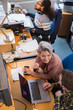 © Chris Ryan/Caia Image - Creative business people meeting, working at laptop in office