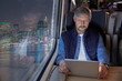 © Agnieszka Olek/Caia Image - Man using digital tablet on passenger train at night