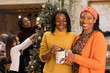 © Sam Edwards/Caia Image - Portrait smiling women sisters holding Christmas gift
