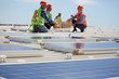 © Trevor Adeline/Caia Image - Engineers installing solar panels at sunny power plant
