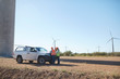 © Trevor Adeline/Caia Image - Engineers meeting at truck at sunny wind turbine power plant