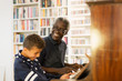 © Tom Merton/Caia Image - Happy grandfather and grandson playing piano