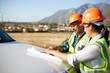 © Trevor Adeline/Caia Image - Engineers reviewing blueprints at truck at sunny power plant