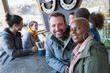 © Chris Ryan/Caia Image - Portrait smiling couple dining with friends at restaurant outdoor patio