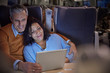 © Agnieszka Olek/Caia Image - Affectionate couple watching movie on digital tablet on on passenger train at night