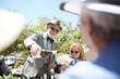 © Trevor Adeline/Caia Image - Senior man in suit bow tie pouring wine for friends at sunny garden party