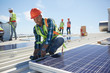 © Trevor Adeline/Caia Image - Engineer installing solar panels at sunny power plant