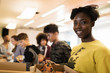 © Sam Edwards/Caia Image - Portrait smiling teenage girl enjoying pizza friends in community center
