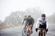 © Richard Johnson/Caia Image - Dedicated male cyclists cycling on rainy road