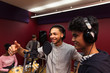 © Sam Edwards/Caia Image - Smiling teenage musicians recording music, singing in sound booth