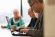© Tom Merton/Caia Image - Focused senior businessman using laptop in conference room meeting