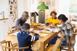 © Tom Merton/Caia Image - Grandparents at dining table with grandchildren doing homework