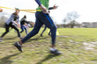 © Sam Edwards/Caia Image - People racing, doing team building exercise in sunny park