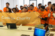 © Martin Barraud/Caia Image - Hackers with banner cheering, coding for charity at hackathon