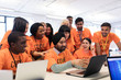 © Sam Edwards/Caia Image - Happy hackers at laptop coding for charity at hackathon
