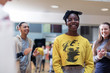 © Sam Edwards/Caia Image - Classmates clapping for smiling teenage girl in dance class studio