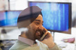 © Sam Edwards/Caia Image - Indian computer programmer in turban talking on smart phone in office