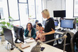 © Sam Edwards/Caia Image - Businesswomen working at computer in open plan office