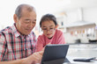 © Sam Edwards/Caia Image - Grandfather and granddaughter using digital tablet
