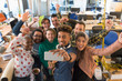 © Chris Ryan/Caia Image - Enthusiastic creative business team cheering, taking selfie in office