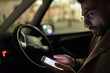 © Paul Bradbury/Caia Image - Man using smart phone in car at night