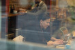 © Paul Bradbury/Caia Image - Smiling businesswoman working at laptop in cafe