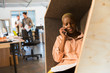 © Chris Ryan/Caia Image - Creative businesswoman talking on smart phone in office cubby