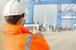 © Rafal Rodzoch/Caia Image - Female dock worker using digital tablet at shipyard