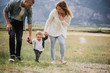 © Jarusha Brown/Caia Image - Parents walking with baby son in rural field