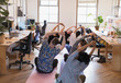 © Tom Merton/Caia Image - Creative business people stretching, practicing yoga in office