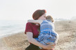 © Tom Merton/Caia Image - Affectionate mother holding daughter on sunny beach