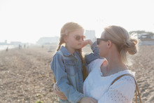 Mother And Daughter Wearing Sunglasses On Sunny Beach