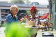 © Tom Merton/Caia Image - Happy young women friends enjoying dim sum lunch at sunny sidewalk cafe