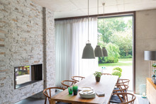 Pendant Lights Over Dining Table In Modern Dining Room With Brick Fireplace