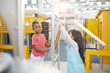 © Trevor Adeline/Caia Image - Curious girls playing at interactive exhibit in science center