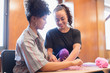 © Tom Merton/Caia Image - Smiling women doing string art project