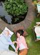 © Tom Merton/Caia Image - Affectionate senior couple laying by pond in garden