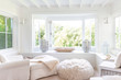 © Charlie Dean/Caia Image - White home showcase sitting area with windows open to garden