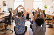 © Tom Merton/Caia Image - Creative business people practicing yoga in office