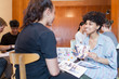 © Tom Merton/Caia Image - Smiling creative female designers discussing photograph proofs in office