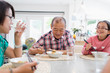 © Sam Edwards/Caia Image - Multi-generation family eating noodles with chopsticks at table
