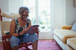 © Robert Daly/Caia Image - Senior woman using digital tablet in living room