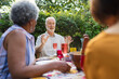 © Robert Daly/Caia Image - Senior friends enjoying lunch, talking at patio table