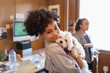 © Tom Merton/Caia Image - Portrait smiling creative businesswoman with cute dog in office