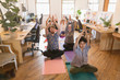 © Tom Merton/Caia Image - Creative business people practicing yoga in office