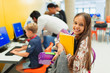 © Paul Bradbury/Caia Image - Portrait smiling, confident junior high girl student carrying books in library
