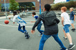 © Paul Bradbury/Caia Image - Junior high boy students playing basketball in schoolyard