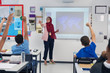© Robert Daly/Caia Image - Female teacher in hijab leading lesson, calling on students in classroom